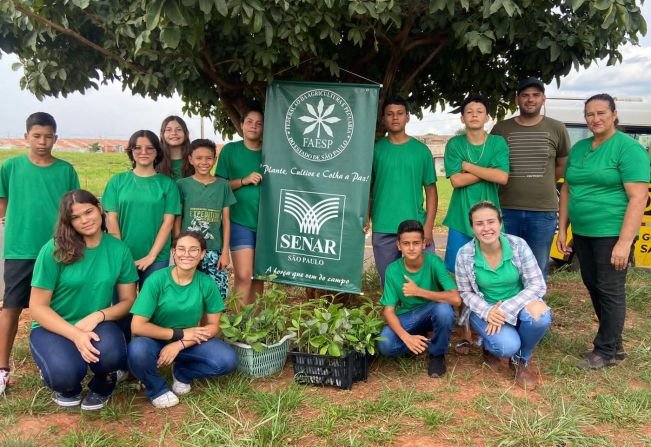 Jovens Agricultores plantam mudas de árvores nativas.